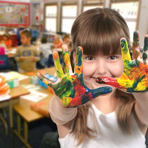 Young School Age Child Painting With Her Hands in Class